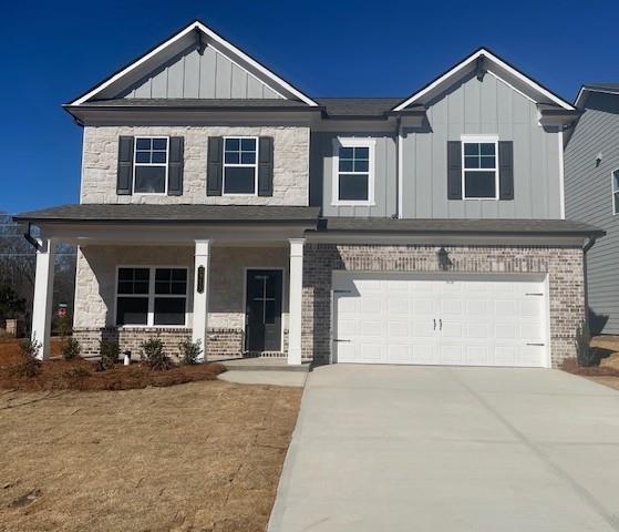 craftsman house with board and batten siding, covered porch, driveway, and an attached garage