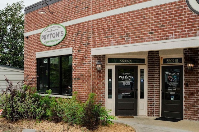 entrance to property featuring brick siding