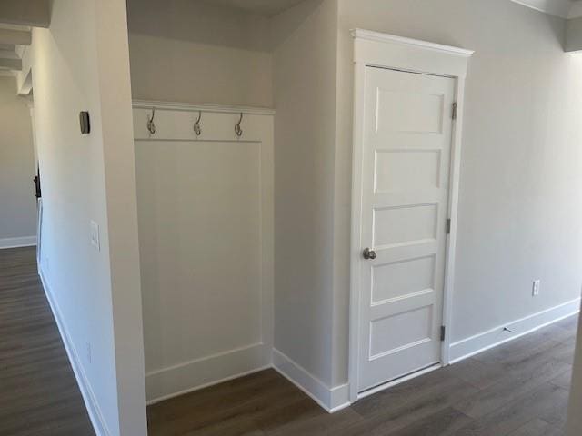 mudroom with dark wood finished floors and baseboards