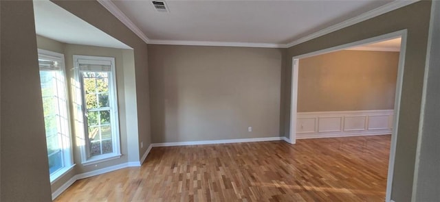 spare room featuring light hardwood / wood-style floors and ornamental molding