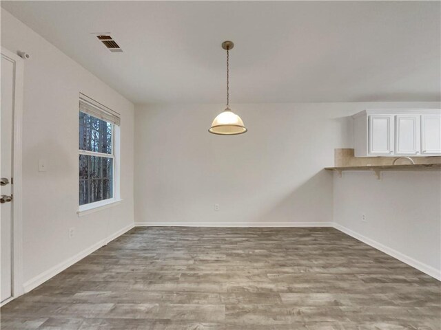 unfurnished dining area featuring wood-type flooring