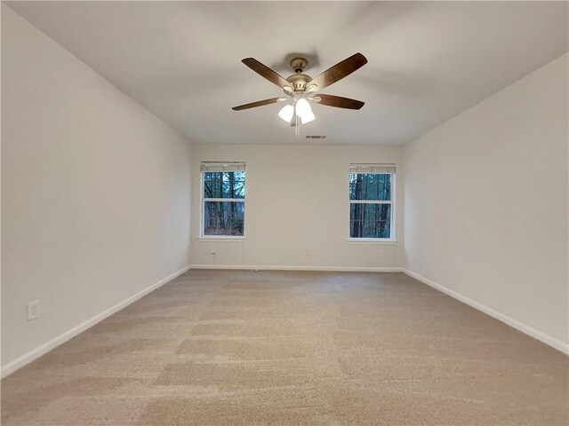 spare room featuring light carpet and ceiling fan