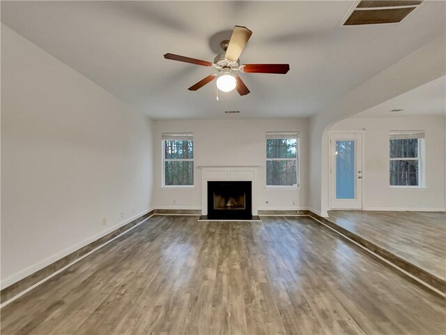 unfurnished living room with hardwood / wood-style flooring, ceiling fan, and plenty of natural light