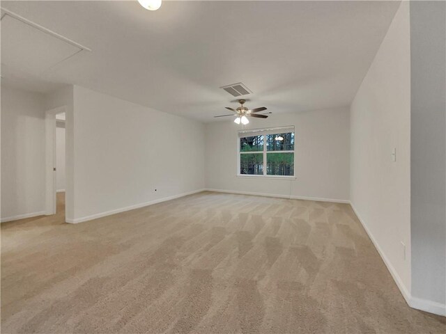 spare room with ceiling fan and light colored carpet