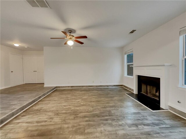 unfurnished living room featuring ceiling fan and hardwood / wood-style flooring