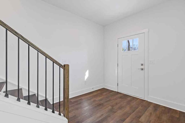 entrance foyer with dark wood-type flooring, stairway, and baseboards