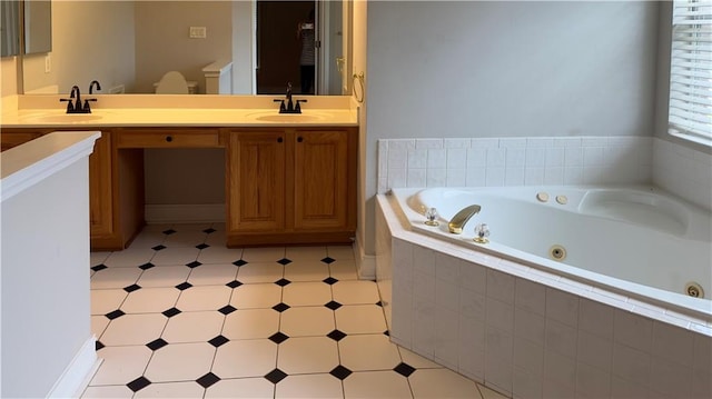 bathroom with tiled bath and vanity