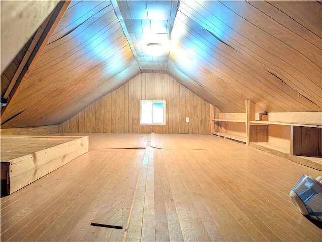 additional living space with vaulted ceiling, wood ceiling, wood walls, and wood-type flooring