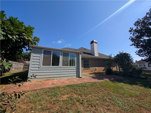 back of property featuring a lawn and a patio