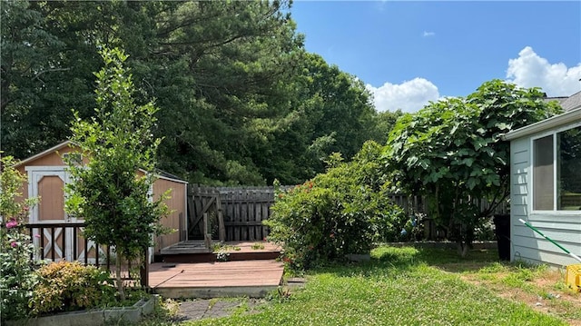 view of yard with a wooden deck and a storage shed