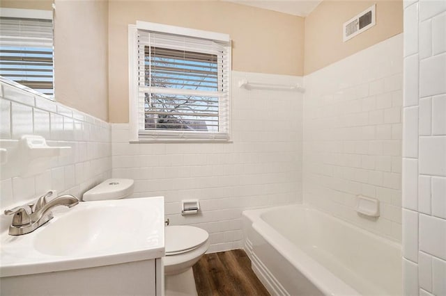 bathroom with toilet, vanity, tile walls, and hardwood / wood-style flooring