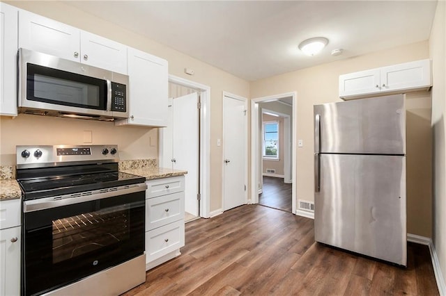 kitchen featuring white cabinets, light stone counters, stainless steel appliances, and dark wood-type flooring