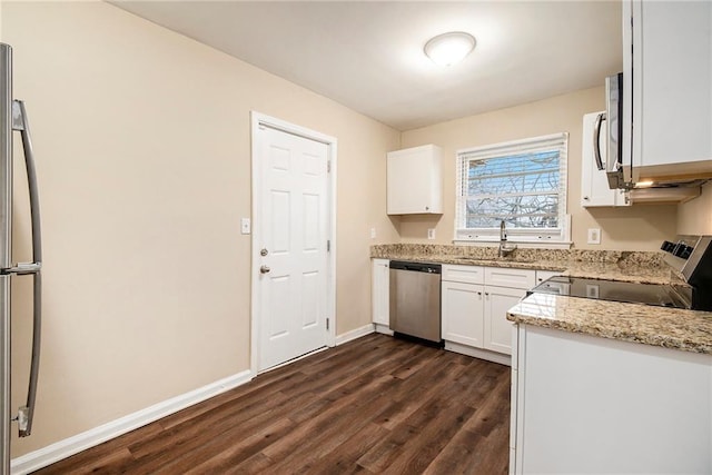 kitchen featuring light stone countertops, stainless steel appliances, sink, dark hardwood / wood-style floors, and white cabinetry