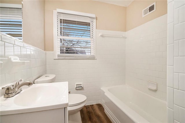 full bathroom with wood-type flooring, vanity, toilet, and tile walls