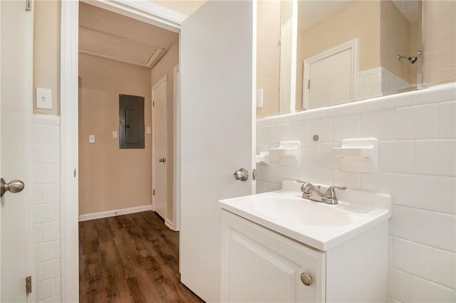 bathroom featuring vanity, wood-type flooring, electric panel, and tasteful backsplash