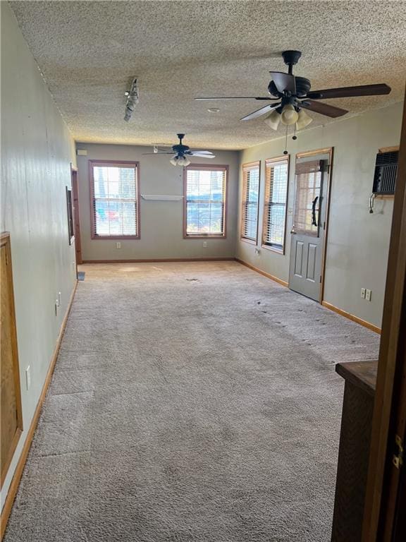 empty room with light carpet, a textured ceiling, and ceiling fan