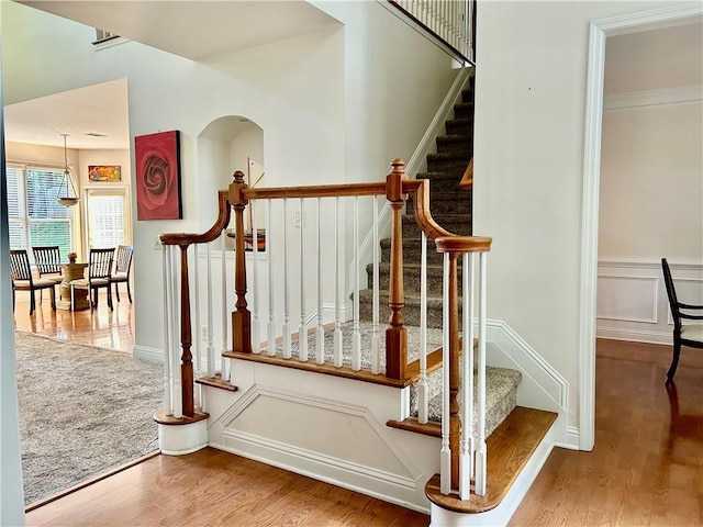 1055 Havenstone Walk, Lawrenceville, GA 30045 - stairs featuring a decorative wall, wood finished floors, and a wainscoted wall