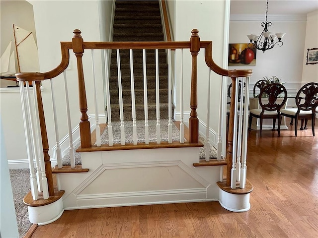 1055 Havenstone Walk, Lawrenceville, GA 30045 - stairway featuring wood finished floors, a chandelier, and crown molding