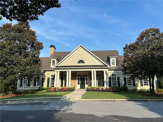1055 Havenstone Walk, Lawrenceville, GA 30045 - view of front facade with roof with shingles, a front yard, a chimney, and stone siding