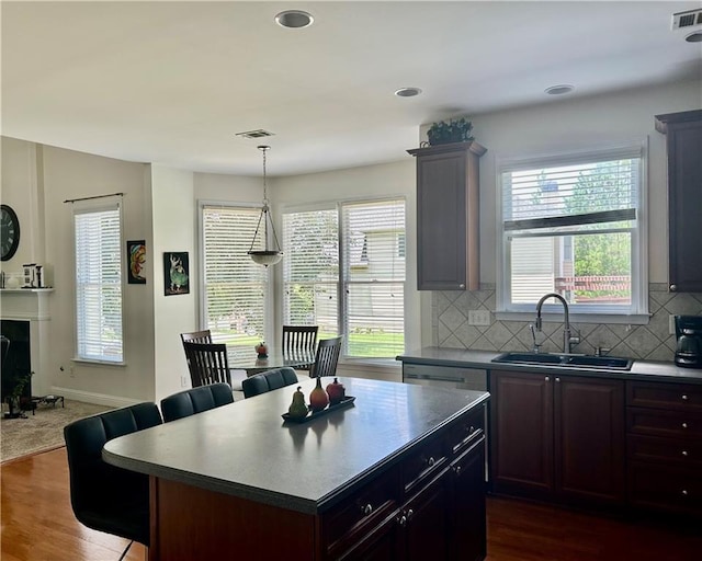 1055 Havenstone Walk, Lawrenceville, GA 30045 - kitchen featuring a breakfast bar, decorative backsplash, dark wood finished floors, a center island, and recessed lighting