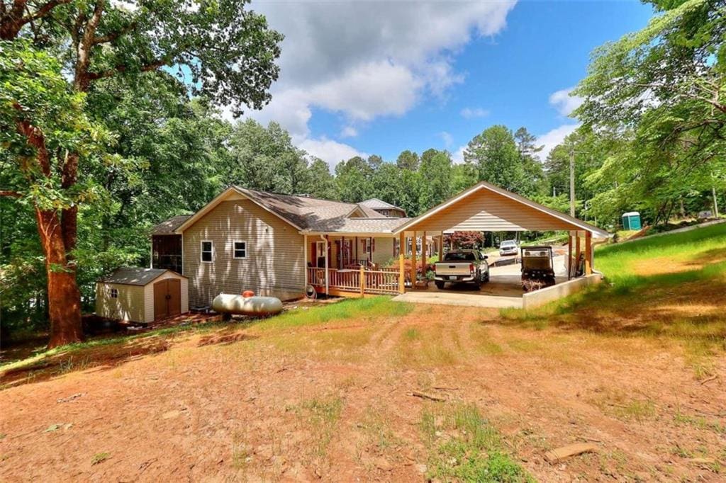 rear view of house with a shed and a carport