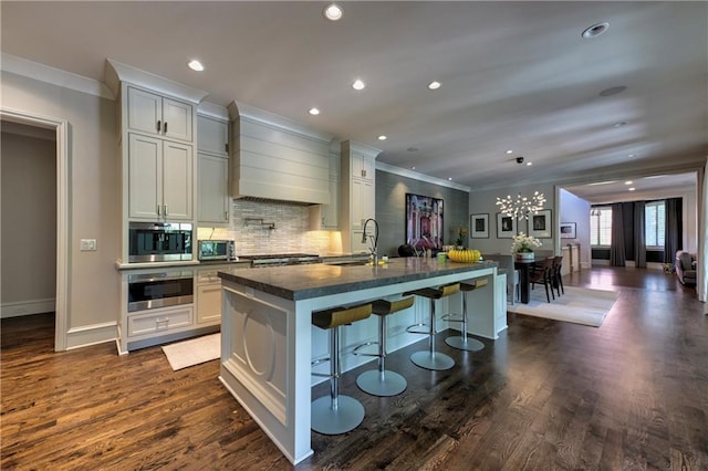201 Dovecrest Dr, Atlanta, GA 30305 - kitchen with a sink, ornamental molding, oven, wall chimney range hood, and an island with sink