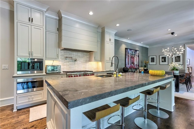 201 Dovecrest Dr, Atlanta, GA 30305 - kitchen with wall chimney exhaust hood, a sink, a kitchen island with sink, dark wood-style flooring, and recessed lighting