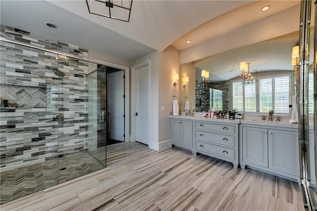 201 Dovecrest Dr, Atlanta, GA 30305 - full bath with double vanity, a shower stall, recessed lighting, a chandelier, and wood finished floors