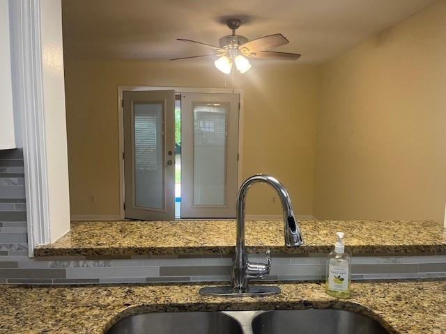 5950 Wintergreen Rd, Norcross, GA 30093 - kitchen view of a sink, a ceiling fan, light stone countertops, and decorative backsplash