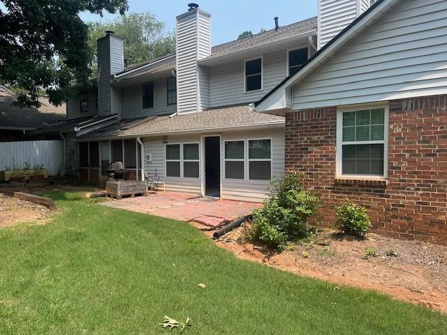 5950 Wintergreen Rd, Norcross, GA 30093 - back of house with a chimney, brick siding, and a yard