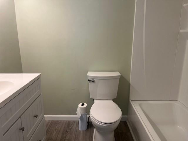 5950 Wintergreen Rd, Norcross, GA 30093 - bathroom featuring baseboards, vanity, a tub, toilet, and wood finished floors