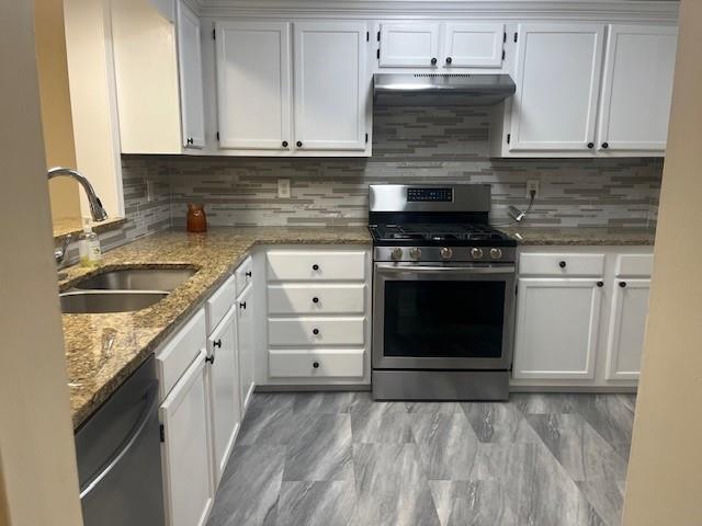 5950 Wintergreen Rd, Norcross, GA 30093 - kitchen with stainless steel appliances, a sink, extractor fan, and white cabinetry