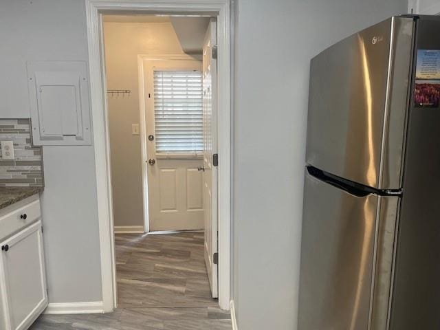 5950 Wintergreen Rd, Norcross, GA 30093 - kitchen featuring freestanding refrigerator, baseboards, wood finished floors, and white cabinetry