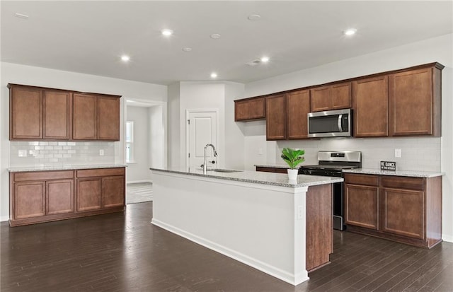 kitchen featuring sink, dark hardwood / wood-style floors, an island with sink, and stainless steel appliances