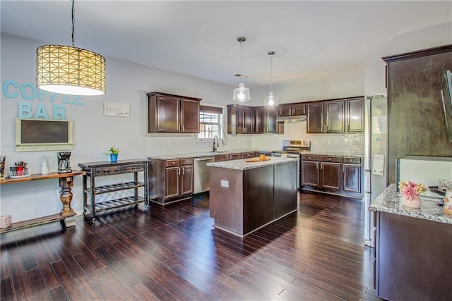 kitchen with dark wood-type flooring, dark brown cabinets, a center island, and hanging light fixtures