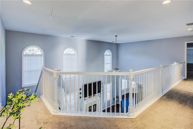 hallway with plenty of natural light and carpet flooring