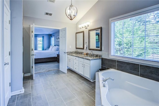 bathroom featuring lofted ceiling, tiled tub, vanity, tile patterned floors, and a chandelier