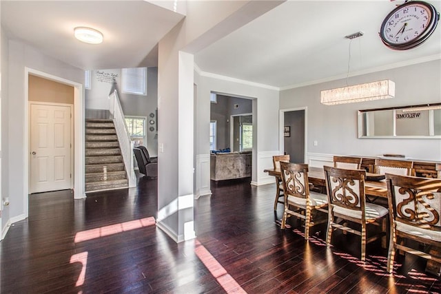 dining space with a wealth of natural light, ornamental molding, and dark hardwood / wood-style floors