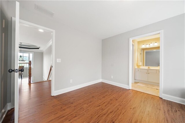 spare room featuring sink and wood-type flooring