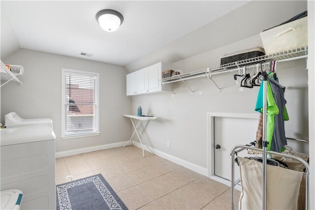 washroom with cabinets, independent washer and dryer, and light tile patterned floors