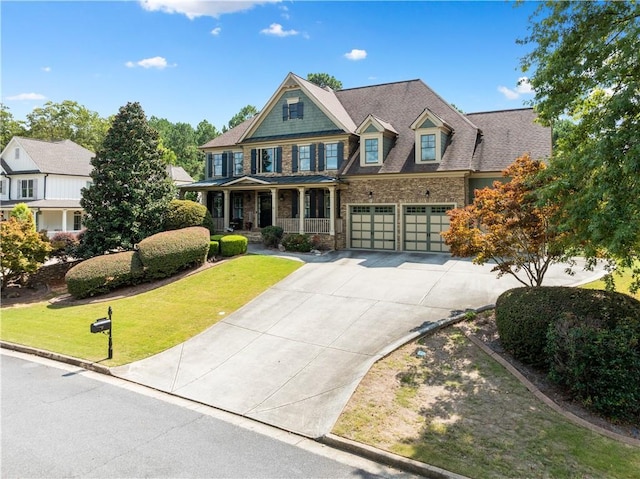 view of front of property featuring a porch, a garage, and a front lawn