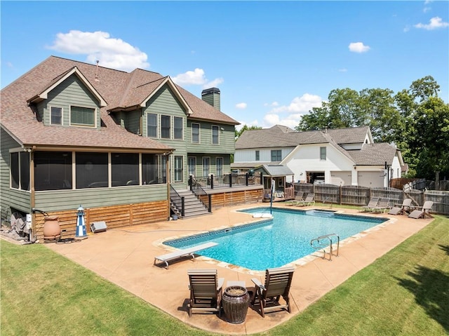 view of swimming pool with a lawn, a sunroom, a patio, and a diving board