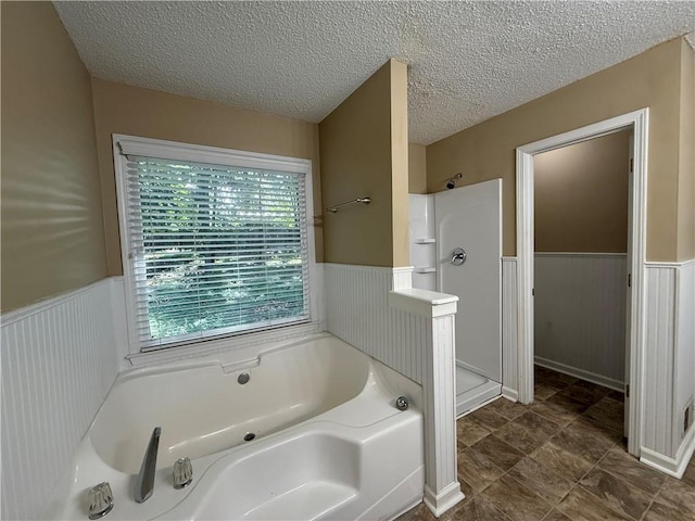 116 Cumberland Way, Dallas, GA 30132 - full bathroom with wainscoting, a bath, a stall shower, and a textured ceiling
