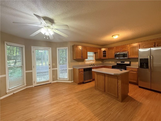 116 Cumberland Way, Dallas, GA 30132 - kitchen featuring stainless steel appliances, light wood-style flooring, brown cabinetry, a textured ceiling, and light countertops
