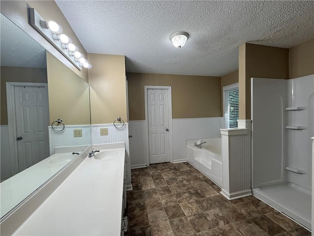 116 Cumberland Way, Dallas, GA 30132 - full bath featuring double vanity, wainscoting, a textured ceiling, a garden tub, and stone finish floors