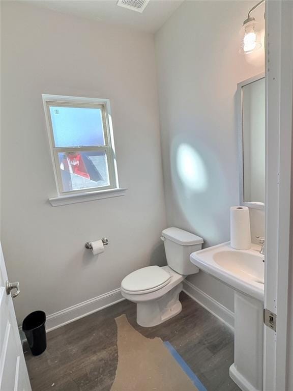 bathroom with wood-type flooring and toilet