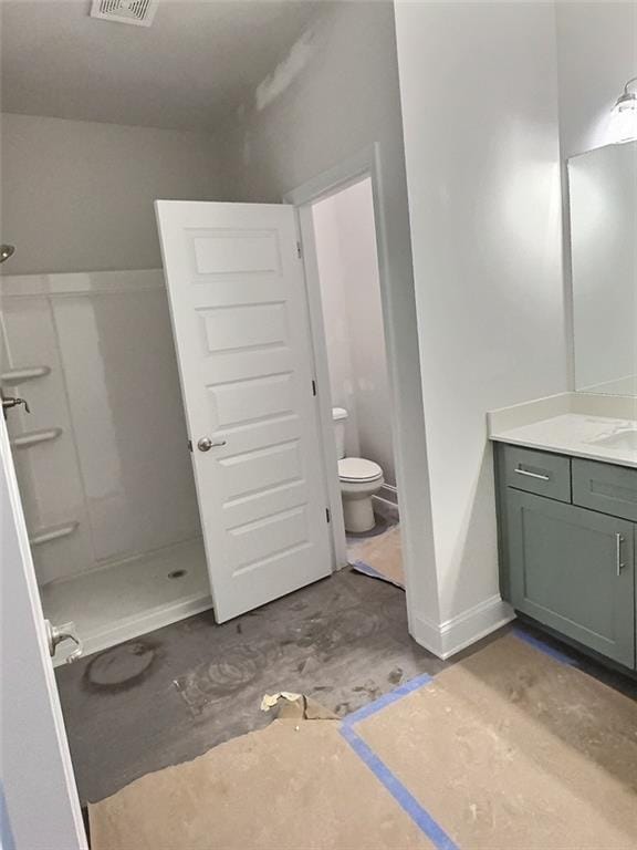 bathroom featuring vanity, toilet, a shower, and concrete floors