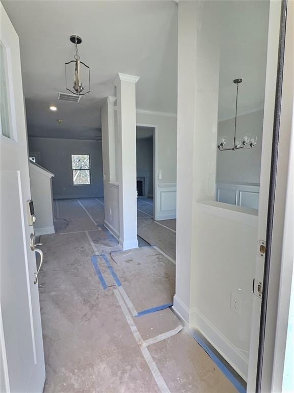 interior space with ornamental molding and an inviting chandelier