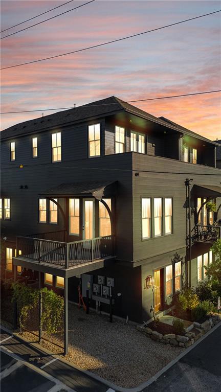 back house at dusk featuring a balcony