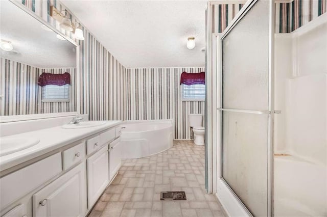 bathroom with a sink, wallpapered walls, a garden tub, and a textured ceiling